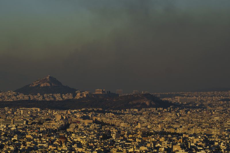 A general view of the of Athens with the Acropolis hill as fire burns the northern part of the city on Monday, Aug. 12, 2024, while hundreds of firefighters tackle a major wildfire raging out of control on fringes of Greek capital. (AP Photo/Petros Giannakouris)