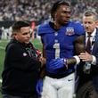 New York Giants wide receiver Malik Nabers (1) is helped off the field after an injury during the fourth quarter of an NFL football game against the Dallas Cowboys, Thursday, Sept. 26, 2024, in East Rutherford, N.J. (AP Photo/Adam Hunger)