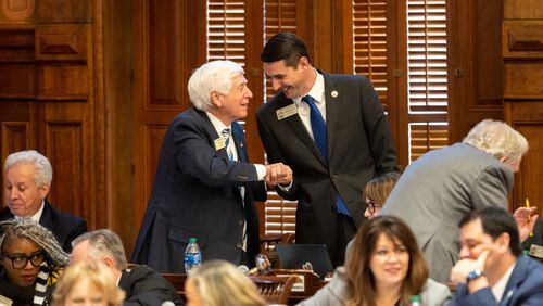 Republican state Rep. Butch Parrish, left, shakes hands with Republican Rep. Trey Kelley after Parrish's House Bill 1339, which would ease regulations involving construction or expansion of hospitals in rural counties, won approval Tuesday in the House. (Arvin Temkar / arvin.temkar@ajc.com)