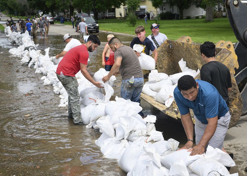 Volunteers stack sandbags at Central Park in Hawarden, Iowa, Saturday, June 22, 2024, in the wake of flooding from the Big Sioux River. Massive upstream rainfall sent the river over its banks in Hawarden causing massing flooding that prompted evacuations. (Tim Hynds/Sioux City Journal via AP)