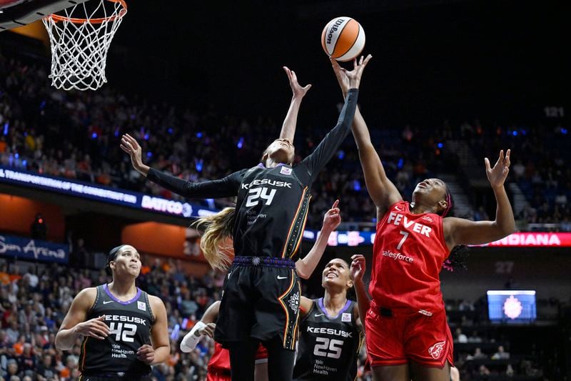 Connecticut Sun forward DeWanna Bonner (24) and Indiana Fever forward Aliyah Boston (7) reach for a rebound during the first half in Game 2 of a first-round WNBA basketball playoff series, Wednesday, Sept. 25, 2024, in Uncasville, Conn. (AP Photo/Jessica Hill)