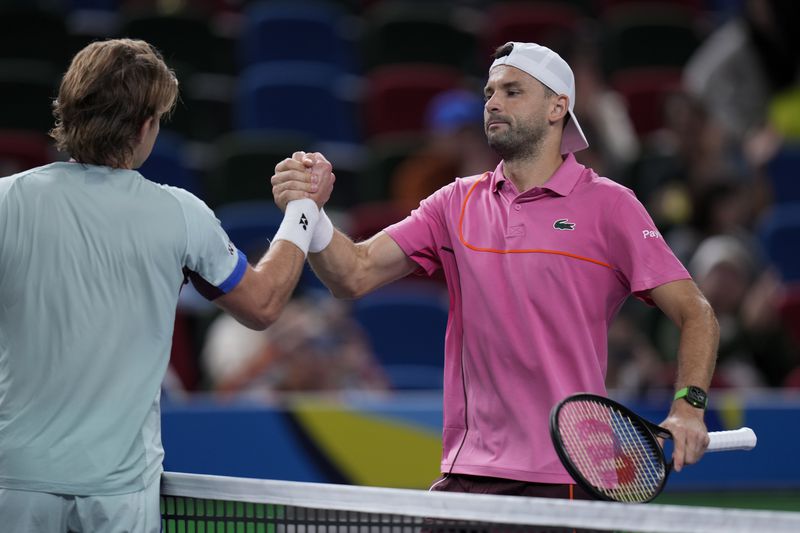 Grigor Dimitrov of Bulgaria, right, is congratulated by Zizou Bergs of Belgium after winning in the men's singles second round match in the Shanghai Masters tennis tournament at Qizhong Forest Sports City Tennis Center in Shanghai, China, Monday, Oct. 7, 2024. (AP Photo/Andy Wong)