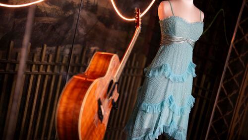 A guitar and stage costume from previous concert tours are displayed at the 'Taylor Swift Songbook Trail Exhibition' at the Victoria & Albert Museum, on Wednesday, July 24, 2024 in London. (Photo by Scott A Garfitt/Invision/AP)