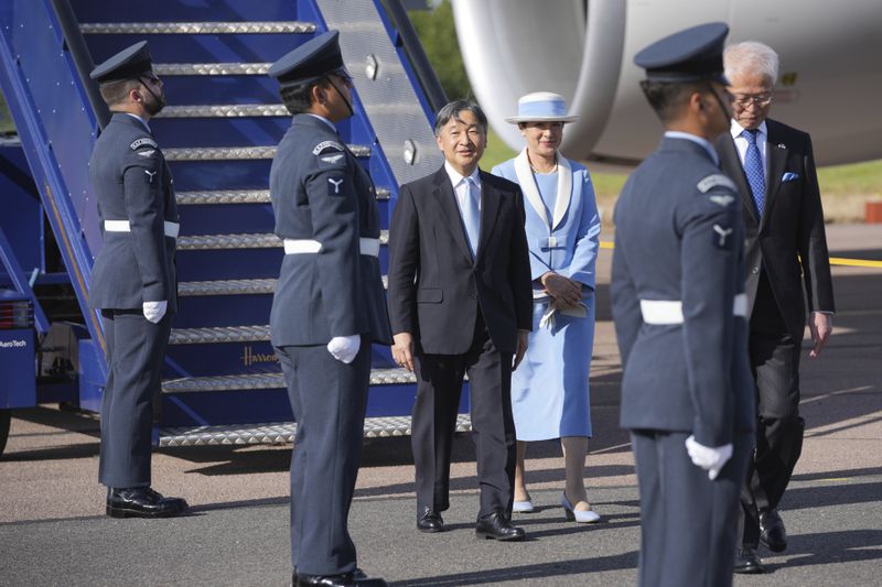 Emperor Naruhito and Empress Masako walk through a guard of honour after arriving at Stansted Airport, England, Saturday, June 22, 2024, ahead of a state visit. The state visit begins Tuesday, when King Charles III and Queen Camilla will formally welcome the Emperor and Empress before taking a ceremonial carriage ride to Buckingham Palace. (AP Photo/Kin Cheung)