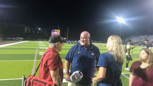 Mill Creek coach Josh Lovelady is congratulated by family after his team beat Cedar Grove 56-35 on Sept. 15, 2023.