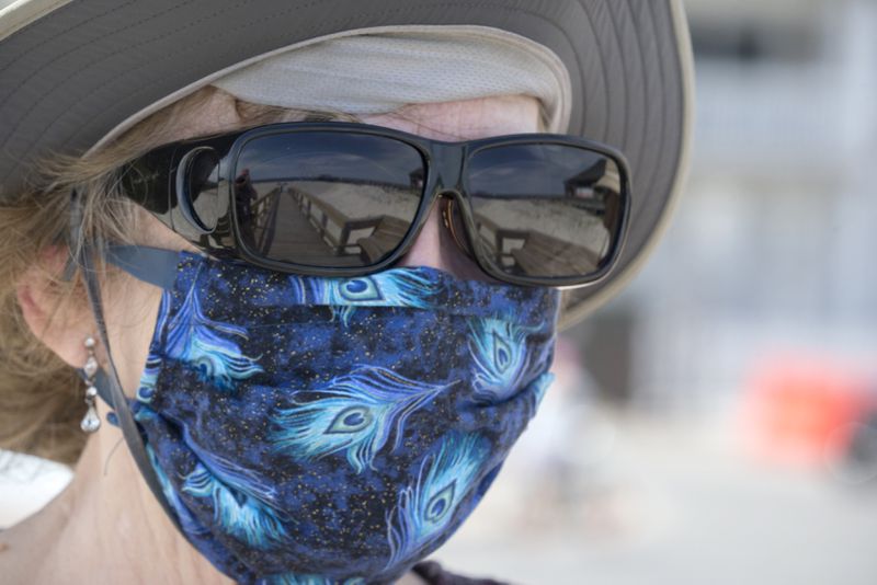 TYBEE ISLAND, GA - APRIL 4, 2020: A local visitor walks along a dune crossover to Tybee Island beach with her hand-made face mask after Gov. Brian Kemp signed an executive order allowing people to exercise outside, with social distancing of at least 6 feet. (AJC Photo/Stephen B. Morton)