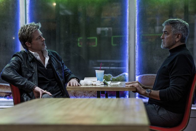 This image released by Apple TV+ shows Brad Pitt, left, and George Clooney in a scene from "Wolfs." (Scott Garfield/Apple TV+ via AP)