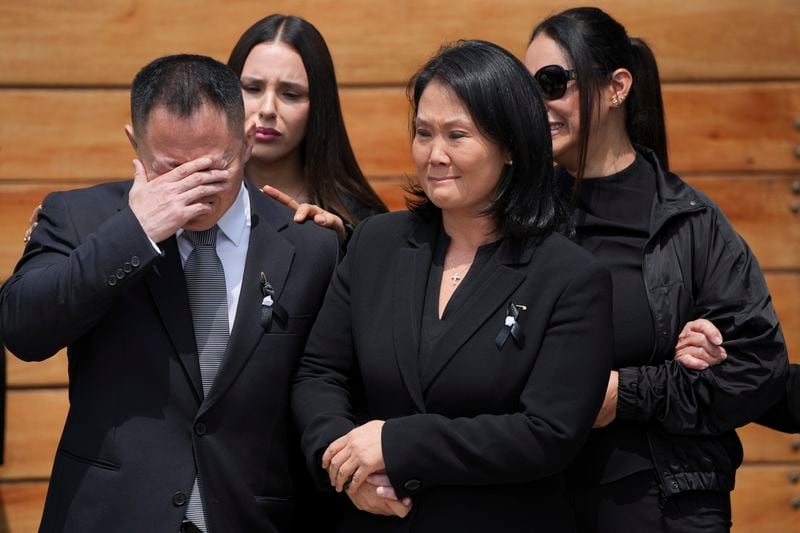 Keiko Fujimori, right, leaves her home with her brother Kenji as pallbearers carry the coffin of their father, former President Alberto Fujimori, the day after he died in Lima, Peru, Thursday, Sept. 12, 2024. (AP Photo/Guadalupe Pardo)