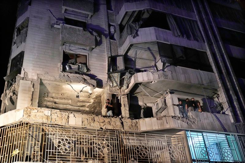 Rescue workers survey an apartment hit by an airstrike in Beirut, Lebanon, Thursday, Oct. 3, 2024. (AP Photo/Hussein Malla)