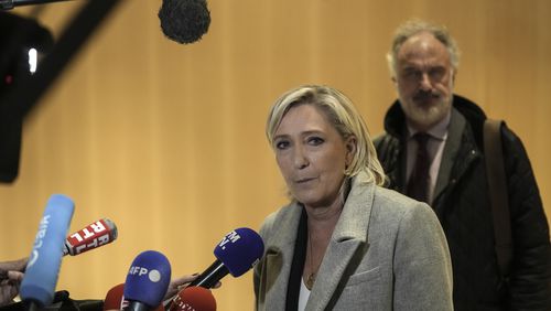 French far-right leader Marine Le Pen, front, speaks to the media as she arrives at the court house in Paris, Monday, Sept. 30, 2024. (AP Photo/Thibault Camus)