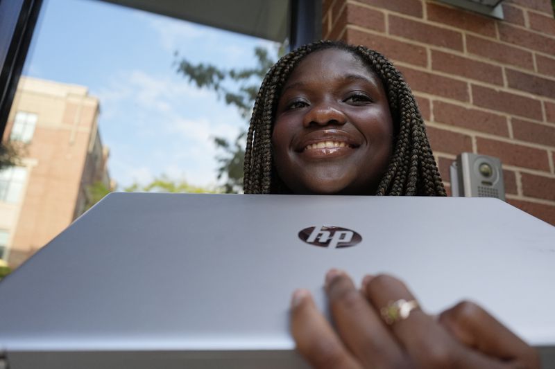 Adjovi Golo smiles as she holds her laptop at DePaul University in Chicago, Wednesday, Aug. 28, 2024. (AP Photo/Nam Y. Huh)