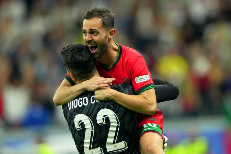 Portugal's goalkeeper Diogo Costa, left, and his teammate Bernardo Silva celebrate their win against Slovenia during a round of sixteen match between Portugal and Slovenia at the Euro 2024 soccer tournament in Frankfurt, Germany, Monday, July 1, 2024. (Spada/LaPresse via AP)