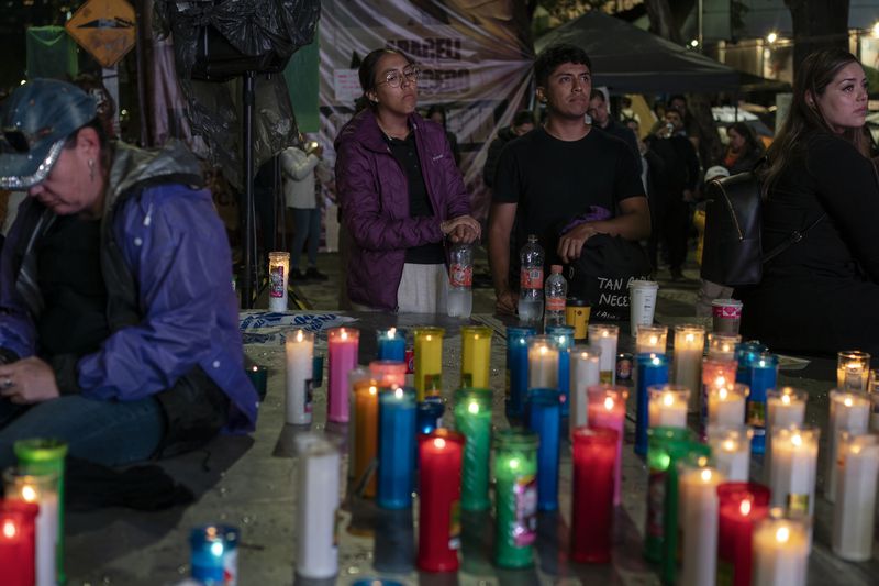 A group of people watch the senators vote on a screen during a protest against the government's proposed judicial reform, which would make judges stand for election, outside the Senate in Mexico City, Tuesday, Sept. 10, 2024. (AP Photo/Felix Marquez)