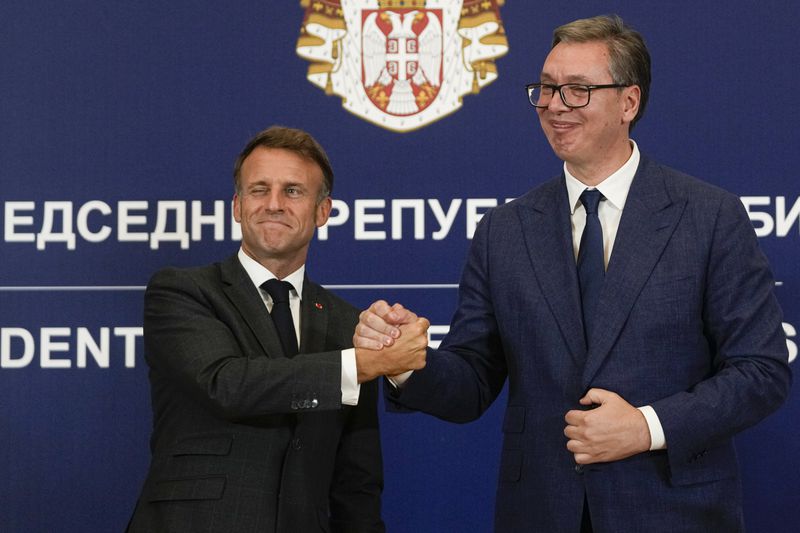 French President Emmanuel Macron clasps hands with Serbian President Aleksandar Vucic after a joint press conference in Belgrade, Serbia, Thursday, Aug. 29, 2024. French President Emmanuel Macron started a two-day state visit to Serbia with the focus on the sale of 12 Rafale multi-purpose fighter jets to a country that has maintained close ties to Russia despite its aggression on Ukraine. (AP Photo/Darko Vojinovic)