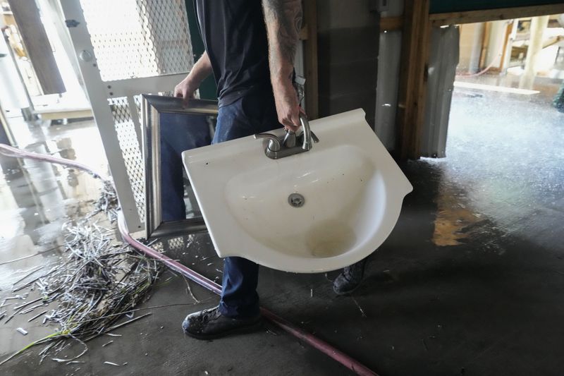 Allen McCoy helps clean out his family's camp that took on a storm surge, in the aftermath of Hurricane Francine, in Cocodrie, La., Thursday, Sept. 12, 2024. (AP Photo/Gerald Herbert)