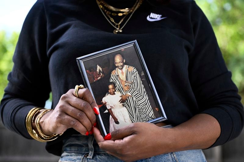 Ferguson activist Brittany Packnett-Cunningham holds a picture of her and her father Rev. Ronald Packnett, Saturday, Sep. 7, 2024, in Mount Rainier, Md. (AP Photo/Terrance Williams)