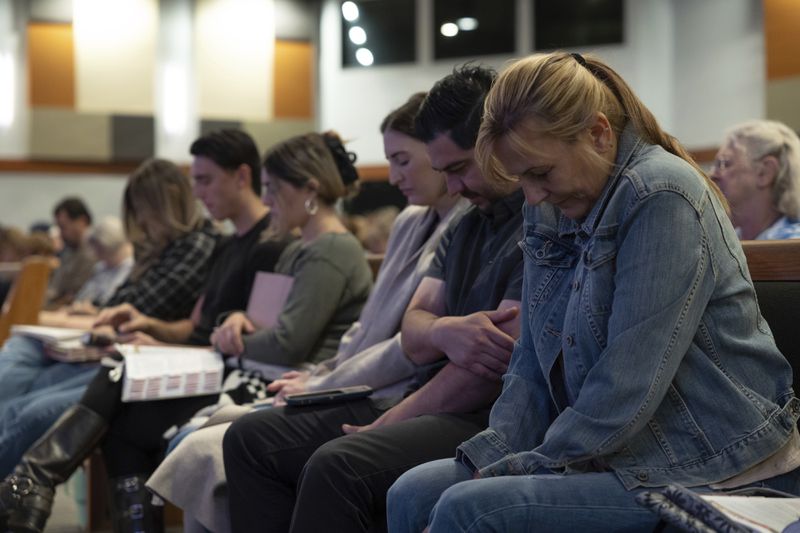 Audience members listen to an opening prayer at a Comeback California Tour event at Revival Fellowship, Saturday, Sept. 21, 2024, in Menifee, Calif. (AP Photo/Zoë Meyers)