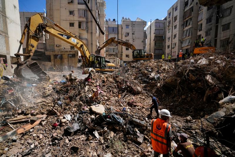 Emergency workers use excavators to clear the rubble at the site of Friday's Israeli strike in Beirut's southern suburbs, Lebanon, Monday, Sept. 23, 2024. (AP Photo/Hassan Ammar)