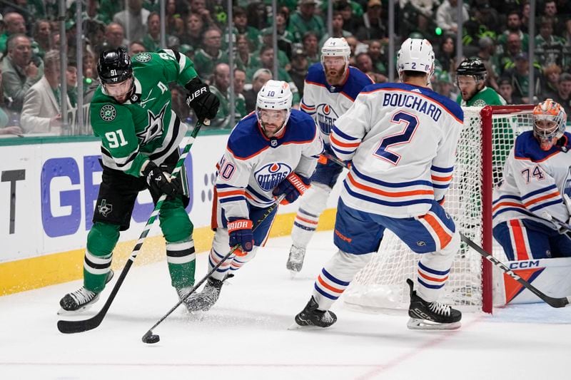 Edmonton Oilers center Derek Ryan (10) takes control of the puck in front of Dallas Stars center Tyler Seguin (91) and Oilers' Evan Bouchard (2) as goaltender Stuart Skinner (74) watches during the first period in Game 2 of the Western Conference finals in the NHL hockey Stanley Cup playoffs Saturday, May 25, 2024, in Dallas. (AP Photo/Tony Gutierrez)