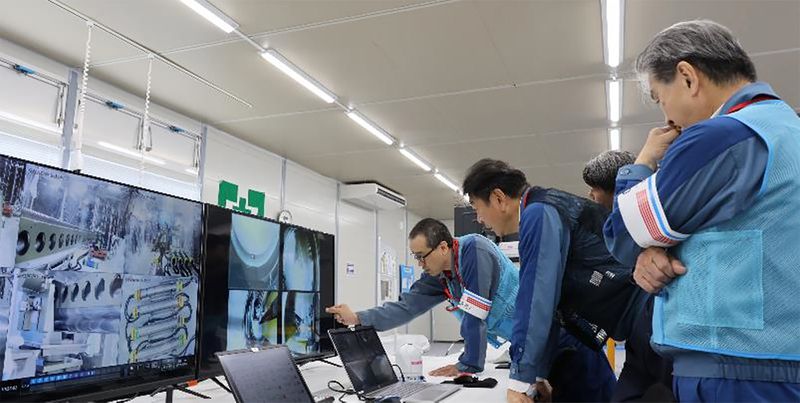 In this photo released by Tokyo Electric Power Company Holdings (TEPCO), TEPCO executives observe plant officials making final procedural checks from an operation room to monitor and remote control an extendable robot, at Fukjushima Daiichi nuclear power plant in Okuma, Fukushima prefecture, northern Japan Monday, Sept. 9, 2024. (Tokyo Electric Power Company Holdings via AP)