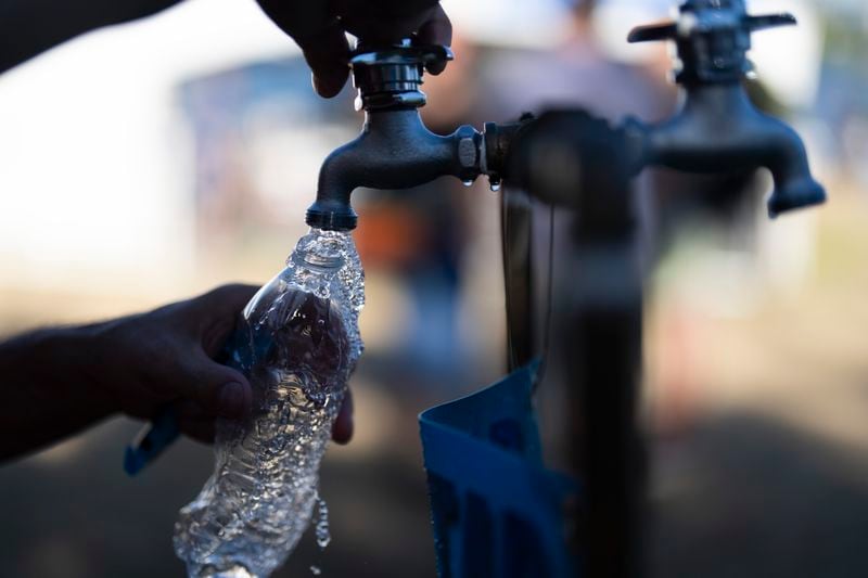 FILE - A person fills their water bottle while attending the Waterfront Blues Festival, July 5, 2024, in Portland, Ore. Record daily high temperatures in Oregon were suspected in four deaths reported in the Portland area Monday, July 8, as much of the country continued to swelter under an early heat wave. (AP Photo/Jenny Kane, File)