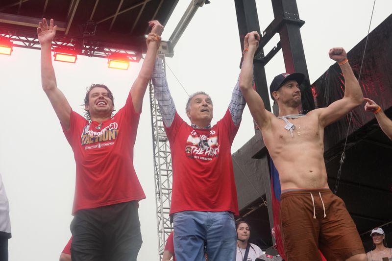 Florida Panthers' Carter Verhaeghe, left, team owner Vincent Viola, center, and goaltender Sergei Bobrovsky, right, raise their arms during an NHL hockey parade and rally, Sunday, June 30, 2024, in Fort Lauderdale, Fla. The Panthers defeated the Edmonton Oilers to win the Stanley Cup. (AP Photo/Marta Lavandier)