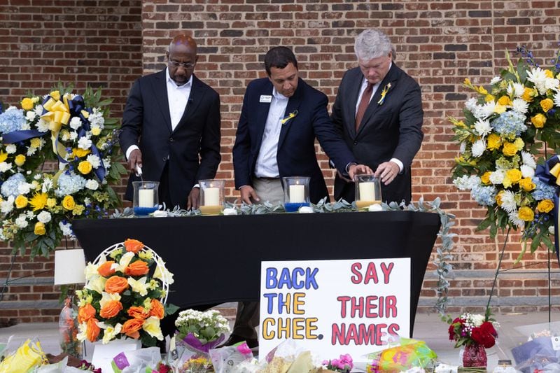 (L-R) U.S. Sen. Raphael Warnock, D-Ga., Barrow County Superintendent Dallas LeDuff, and U.S. Rep. Mike Collins, R-Jackson, light candles at a vigil at Jug Tavern Park in Winder on Friday, Sept. 6, 2024. A 14-year-old Apalachee High School student is accused of shooting and killing two fellow students and two teachers and injuring nine others at the Barrow County high school on Wednesday. (Arvin Temkar / AJC)