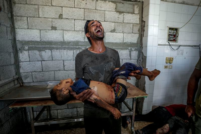 A Palestinian man mourns a relative killed in the Israeli bombardment of the Gaza Strip at a hospital morgue in Deir al-Balah, Wednesday, Aug. 28, 2024. (AP Photo/Abdel Kareem Hana)