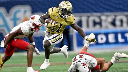 Georgia Tech's running back Jamal Haynes (11) leaps over Louisville's linebacker Keith Brown (22) during the first half of the inaugural Aflac Kickoff Game at Mercedes-Benz Stadium, Friday, September 1, 2023, in Atlanta. Louisville won 39-34 over Georgia Tech. (Hyosub Shin / Hyosub.Shin@ajc.com)