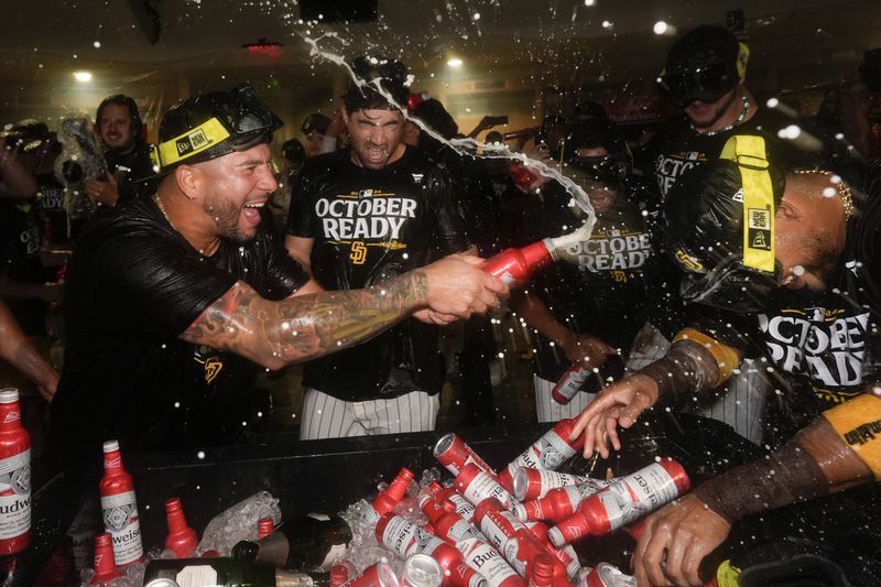 San Diego Padres players celebrate in the dugout after defeating the Atlanta Braves in Game 2 of an NL Wild Card Series baseball game Wednesday, Oct. 2, 2024, in San Diego. (AP Photo/Gregory Bull)