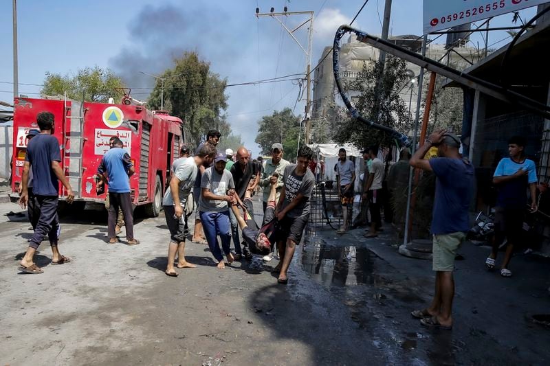 EDS NOTE: GRAPHIC CONTENT - Palestinians evacuate the body of a man from a site hit by an Israeli bombardment on Khan Younis, southern Gaza Strip, Saturday, July 13, 2024. Israel said it targeted Hamas' shadowy military commander in a massive strike Saturday in the crowded southern Gaza Strip that killed at least 71 people, according to local health officials. Hamas immediately rejected the claim that Mohammed Deif was targeted. (AP Photo/Jehad Alshrafi)