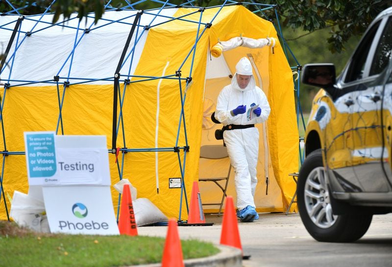 A medical professional in protective equipment prepares to collect a sample from a potential COVID-19 patient at a Phoebe Putney Health System drive-thru testing site in Albany on March 24, 2020. (Hyosub Shin / Hyosub.Shin@ajc.com)