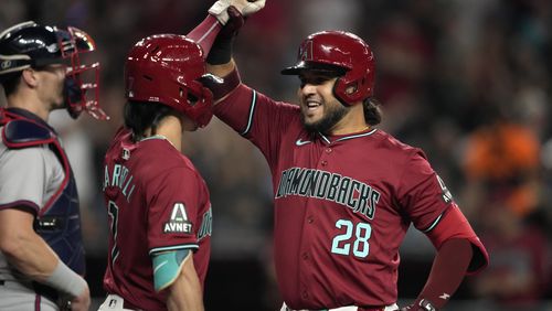 Arizona Diamondbacks' Eugenio Suárez celebrates his solo home run during the fifth inning of a baseball game against the Atlanta Braves with teammate Corbin Carroll, left, Thursday, July 11, 2024, in Phoenix. (AP Photo/Matt York)