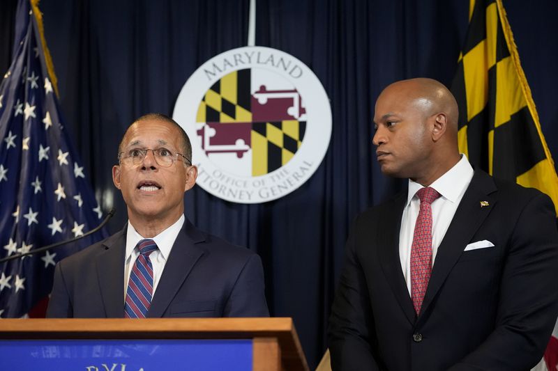 Maryland Attorney General Anthony Brown, left, speaks as Gov. Wes Moore listens during a news conference announcing a lawsuit seeking damages from the owners and managers of the Dali cargo ship that crashed into the Francis Key Scott Bridge, Tuesday, Sept. 24, 2024, in Baltimore. (AP Photo/Stephanie Scarbrough)