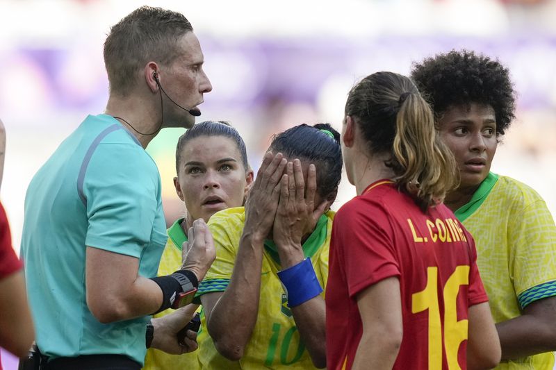 Brazil's Marta, center, reacts after receiving a red card from referee Espen Eskas during a women's Group C soccer match between Brazil and Spain, at Bordeaux Stadium, during the 2024 Summer Olympics, Wednesday, July 31, 2024, in Bordeaux, France. (AP Photo/Moises Castillo)