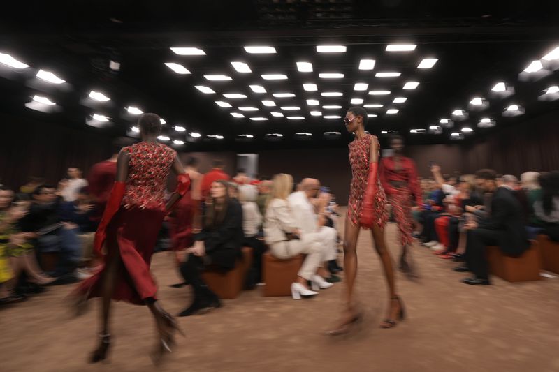 Models wear creations as part of the Ferrari Spring Summer 2025 collection, that was presented in Milan, Italy, Saturday, Sept. 21, 2024. (AP Photo/Luca Bruno).