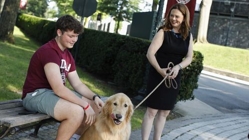 Tania Tetlow president of Fordham University holds her dog Archie as new students arrive during Move In Day at the Bronx campus, Sunday Aug. 25, 2024, in New York. (AP Photo/Kena Betancur)