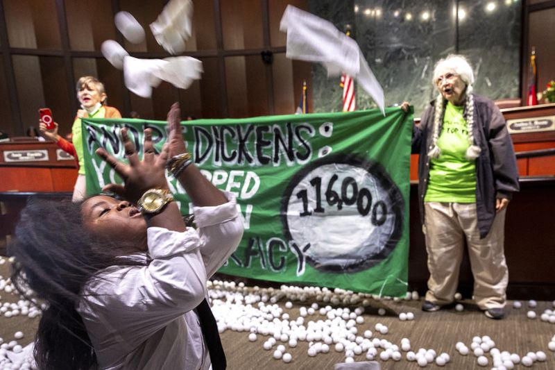 Ping pong balls litter the floor after opponents of the under-construction law enforcement training center known to some as Cop City disrupted the City Council meeting at City Hall in Atlanta on Monday, Sept. 16, 2024. (Arvin Temkar/Atlanta Journal-Constitution via AP)