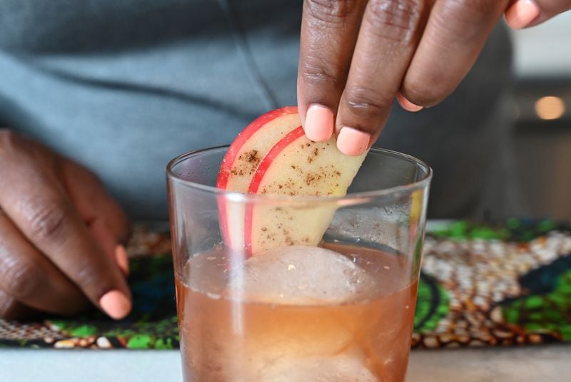 Tiffanie Barriere's Gingerbread Old Fashioned is served in a rocks glass and garnished with sliced apple dusted with cinnamon. (Hyosub Shin / Hyosub.Shin@ajc.com)