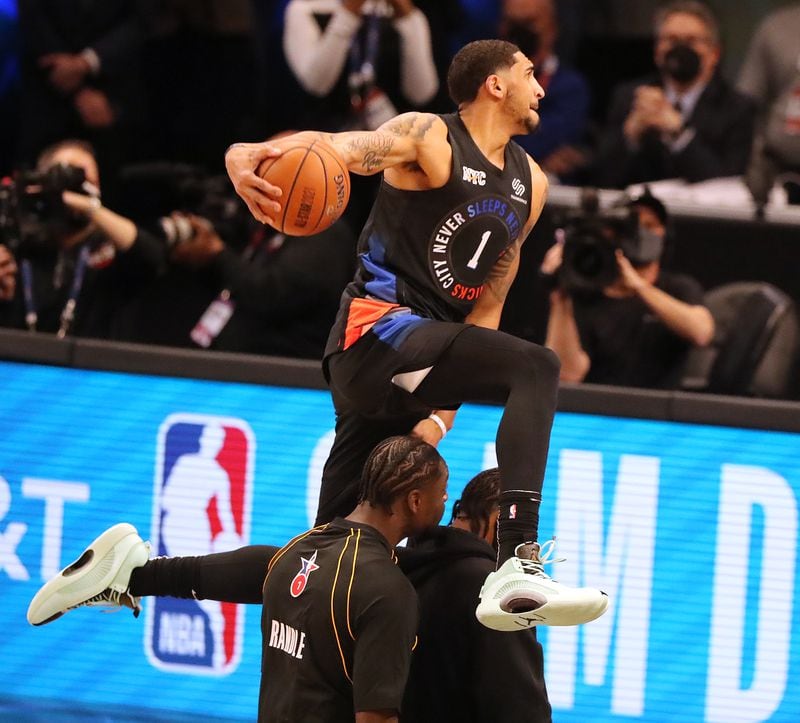 Obi Toppin goes over teammate Julius Randle and his father, Obadiah Toppin, during his attempt in the Slam Dunk contest of the 2021 NBA All-Star Game Sunday, March 7, 2021, at State Farm Arena in Atlanta. (Curtis Compton / Curtis.Compton@ajc.com)