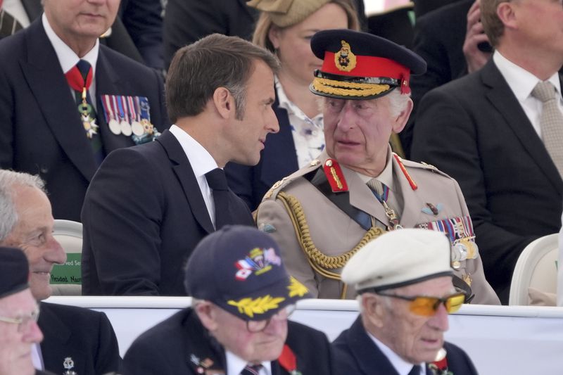 Britain's King Charles III speaks with President of France Emmanuel Macron at the UK national commemorative event for the 80th anniversary of D-Day, held at the British Normandy Memorial in Ver-sur-Mer, Normandy, France, Thursday June 6, 2024. (Gareth Fuller, Pool Photo via AP)