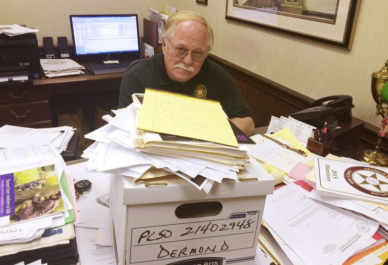 In 2015, a year after the deadly crimes, Putnam County Sheriff Howard Sills inspects the already collected documents related to the murders of Russell and Shirley Dermond.  (Photo: Christian Boone/AJC)