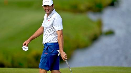 Scottie Scheffler, of the United States, smiles on the 11th green during a practice round for the men's golf event at the 2024 Summer Olympics, Monday, July 29, 2024, at Le Golf National in Saint-Quentin-en-Yvelines, France. (AP Photo/Matt York)