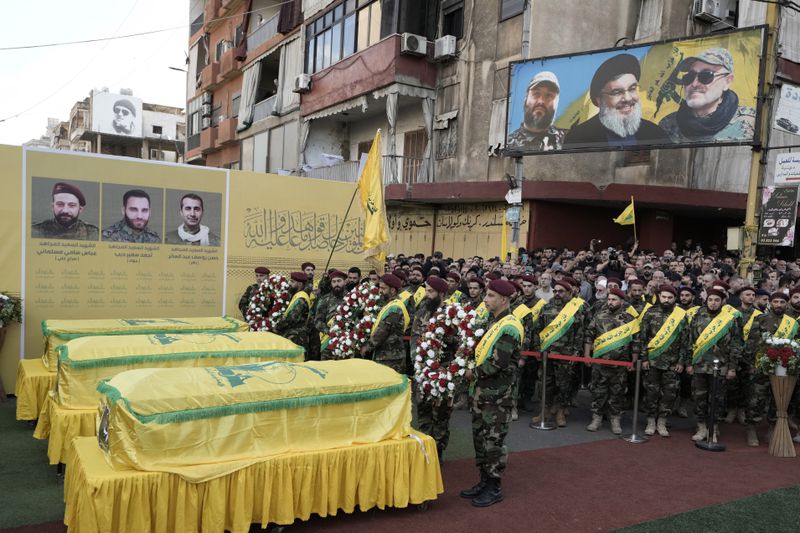 Hezbollah fighters carry wreaths during the funeral procession of their comrades who were killed in Friday's Israeli strike, in the southern suburb of Beirut, Saturday, Sept. 21, 2024. (AP Photo/Bilal Hussein)