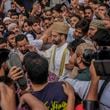 FILE- Supporters assemble to welcome top Kashmiri separatist leader Mirwaiz Umar Farooq, center, as he arrives to offer Friday prayers outside the Jamia Masjid or Grand Mosque in Srinagar, Indian controlled Kashmir, Sept. 22, 2023. (AP Photo/Mukhtar Khan, File)