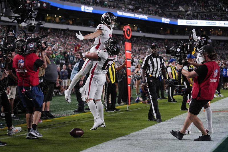 Falcons wide receiver Drake London (5) celebrates his game-winning touchdown with guard Chris Lindstrom.