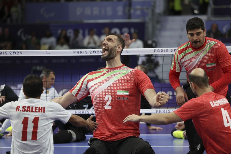 Iran's Morteza Mehrzadselakjani, centre, celebrate with teammates after winning the men's Sitting Volleyball Gold Medal Match between Iran and Bosnia and Herzegovina, at the 2024 Paralympics, Friday, Sept. 6, 2024, in Paris, France. (AP Photo/Leighton Smithwick)