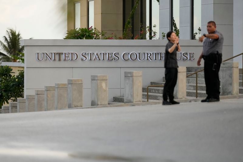 Officials outside the courthouse where WikiLeaks founder Julian Assange is expected to enter a plea deal, in Saipan, Mariana Islands, Wednesday, June 26 2024. (AP Photo/Eugene Hoshiko)
