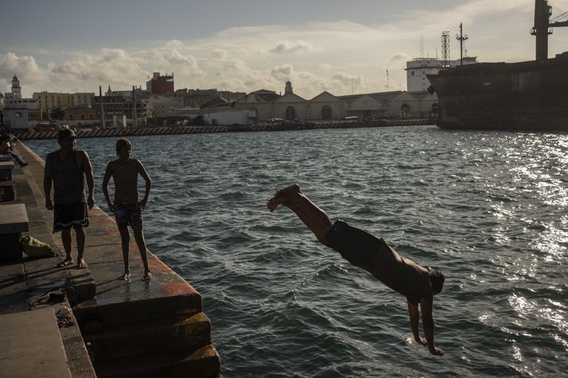 Pedro Murillo, a diver, jumps into the sea amid the heat in Veracruz, Mexico, Saturday, June 15, 2024. Victims in Veracruz have made up nearly a third of Mexico's heat-related deaths as temperatures have reached 100 degrees in the humid Mexican gulf state. (AP Photo/Felix Marquez)