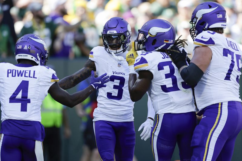 Minnesota Vikings wide receiver Jordan Addison (3) celebrates his touchdown with teammates, Brandon Powell (4), Aaron Jones (33) and Tyrese Robinson (79) during the first half of an NFL football game against the Green Bay Packers, Sunday, Sept. 29, 2024, in Green Bay, Wis. (AP Photo/Matt Ludtke)